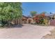 Charming home featuring unique architecture, mature trees, desert landscaping, and a textured concrete driveway at 1702 W Monterosa W St, Phoenix, AZ 85015