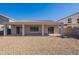 Rear exterior of home, featuring a covered patio and rock landscaping at 17844 W Caribbean Ln, Surprise, AZ 85388