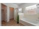 Bathroom featuring a shower with glass doors, bathtub, and a window for natural light at 17844 W Caribbean Ln, Surprise, AZ 85388