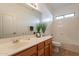 Bright bathroom featuring vanity, framed mirror, bathtub, and a window at 17844 W Caribbean Ln, Surprise, AZ 85388