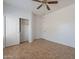 Bedroom featuring tile flooring, a ceiling fan, and a closet with sliding doors at 17844 W Caribbean Ln, Surprise, AZ 85388