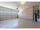 Garage featuring garage door, storage cabinets, and water softener system at 17844 W Caribbean Ln, Surprise, AZ 85388