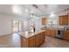 Open kitchen with island, wood cabinets, and a sliding door leading to the backyard at 17844 W Caribbean Ln, Surprise, AZ 85388