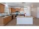 Bright kitchen with island, stone countertops, stainless steel appliances, and natural wood cabinetry at 17844 W Caribbean Ln, Surprise, AZ 85388