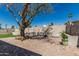 A spacious backyard featuring brick patio, grass, mature tree and block wall at 18233 N 55Th Dr, Glendale, AZ 85308