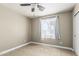A naturally lit bedroom with a ceiling fan, tiled floor and neutral color pallete at 18233 N 55Th Dr, Glendale, AZ 85308