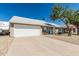 Inviting single-story home with a two-car garage, appealing front yard, and a blue front door at 18233 N 55Th Dr, Glendale, AZ 85308