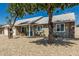 Quaint single-story home with mature shade trees, appealing front yard, and a blue front door at 18233 N 55Th Dr, Glendale, AZ 85308