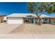Charming single-story home featuring a well-maintained lawn, a blue front door, and a two car garage at 18233 N 55Th Dr, Glendale, AZ 85308