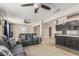 Spacious living room with tile floors, gray sofas with decorative pillows, and open access to the kitchen at 18233 N 55Th Dr, Glendale, AZ 85308