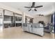 Open-concept living room featuring tile floors, ceiling fans, and gray reclining sofas at 18233 N 55Th Dr, Glendale, AZ 85308