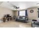 Comfortable living room with tile floors, fan, and a gray reclining sofa below a window with blue curtains at 18233 N 55Th Dr, Glendale, AZ 85308