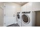 Bright laundry room with white washer and dryer, a door leading outside, and white cabinets at 1834 W Nighthawk Way, Phoenix, AZ 85045