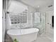 Bright primary bathroom featuring a standalone tub, glass shower and block window for privacy and style at 1834 W Nighthawk Way, Phoenix, AZ 85045