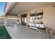 A cozy covered patio with comfortable seating offers a serene outdoor living space with views of the landscaped backyard at 1834 W Nighthawk Way, Phoenix, AZ 85045