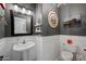 Cozy powder room with white wainscoting, gray paint, and a unique chandelier, creating a welcoming atmosphere at 1834 W Nighthawk Way, Phoenix, AZ 85045