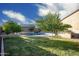 Large, grass-filled backyard with mature landscaping and pool in the background at 18544 W Devonshire Ave, Goodyear, AZ 85395