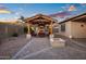 Backyard view featuring a pool, an outdoor covered patio, and a fire pit at dusk at 18544 W Devonshire Ave, Goodyear, AZ 85395