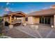 Backyard showing a pool, covered patio, fire pit, green grass, and beautiful landscaping at dusk at 18544 W Devonshire Ave, Goodyear, AZ 85395