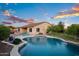 Backyard featuring a pool, covered outdoor living area, and beautiful landscaping at dusk at 18544 W Devonshire Ave, Goodyear, AZ 85395