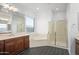Bright bathroom featuring a soaking tub, glass-enclosed shower, and double vanity sinks at 18544 W Devonshire Ave, Goodyear, AZ 85395