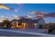 Well-maintained home with solar panels, stone accents, and a paved driveway leading to a two-car garage at 18544 W Devonshire Ave, Goodyear, AZ 85395