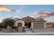 Charming, single-story home with a stone accent, two-car garage, solar panels, and desert landscaping at 18544 W Devonshire Ave, Goodyear, AZ 85395