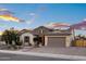 Charming, single-story home with a stone accent, two-car garage, solar panels, and desert landscaping at 18544 W Devonshire Ave, Goodyear, AZ 85395
