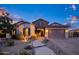 Charming single-story home showcasing a stone facade, manicured landscape, and a welcoming brick pathway at 18544 W Devonshire Ave, Goodyear, AZ 85395