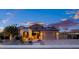 Well-maintained home with stone accents, solar panels, landscaped yard, and a paved driveway leading to a two-car garage at 18544 W Devonshire Ave, Goodyear, AZ 85395