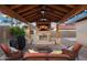 Inviting outdoor living space with covered patio, stone fireplace, tv, and comfortable seating at 18544 W Devonshire Ave, Goodyear, AZ 85395