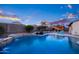 Inviting pool with a waterfall feature and a covered patio area, perfect for relaxation and outdoor entertaining at 18544 W Devonshire Ave, Goodyear, AZ 85395