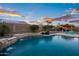 Inviting pool with a waterfall feature and a covered patio area, perfect for relaxation and outdoor entertaining at 18544 W Devonshire Ave, Goodyear, AZ 85395