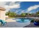 Beautiful private backyard swimming pool with rock waterfall feature and well maintained landscaping at 18544 W Devonshire Ave, Goodyear, AZ 85395