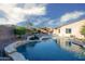 Beautiful backyard oasis with pool, rock waterfall, mature landscaping, and covered patio at 18544 W Devonshire Ave, Goodyear, AZ 85395