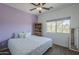 This cozy bedroom features a calming purple accent wall, natural light, and a ceiling fan at 18811 E Pelican Ct, Queen Creek, AZ 85142