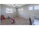 Bonus room featuring a ceiling fan, carpet floors, several windows, and gymnastics equipment at 18811 E Pelican Ct, Queen Creek, AZ 85142
