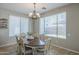 Bright dining room featuring a chandelier, large windows, and a dining table with seating for six people at 18811 E Pelican Ct, Queen Creek, AZ 85142
