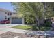Two-story home featuring a two-car garage, manicured lawn, and lush landscaping at 18811 E Pelican Ct, Queen Creek, AZ 85142