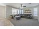 Comfortable living room with a gray sectional sofa, natural light, and neutral walls at 18811 E Pelican Ct, Queen Creek, AZ 85142