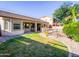 Spacious backyard with covered patio, lush green grass and a safety fenced pool, perfect for entertaining at 19403 E Arrowhead Trl, Queen Creek, AZ 85142