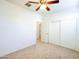 Neutral carpeted bedroom featuring a ceiling fan and a double door closet at 19403 E Arrowhead Trl, Queen Creek, AZ 85142