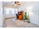 Bright bedroom featuring a ceiling fan, natural light, and a functional desk space at 19403 E Arrowhead Trl, Queen Creek, AZ 85142