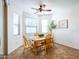 Bright dining area features a wooden table, four chairs, and a modern ceiling fan at 19403 E Arrowhead Trl, Queen Creek, AZ 85142