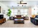 Inviting living room with a brown leather sofa, plush seating, and bright natural light at 19403 E Arrowhead Trl, Queen Creek, AZ 85142
