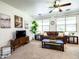Cozy living room showcasing neutral colors, a ceiling fan, a comfortable sofa, and a large window at 19403 E Arrowhead Trl, Queen Creek, AZ 85142