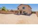 Wide backyard offering a covered patio, privacy wall, and low maintenance desert landscaping at 22196 W Tonto St, Buckeye, AZ 85326