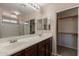 Bathroom with double vanity, dark cabinets, large mirror, and ample storage space at 22196 W Tonto St, Buckeye, AZ 85326