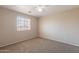 A well-lit bedroom featuring neutral walls, carpet flooring, and a window providing natural light at 22196 W Tonto St, Buckeye, AZ 85326