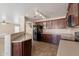 An open kitchen with dark cabinets, tile floors, and a black refrigerator at 22196 W Tonto St, Buckeye, AZ 85326